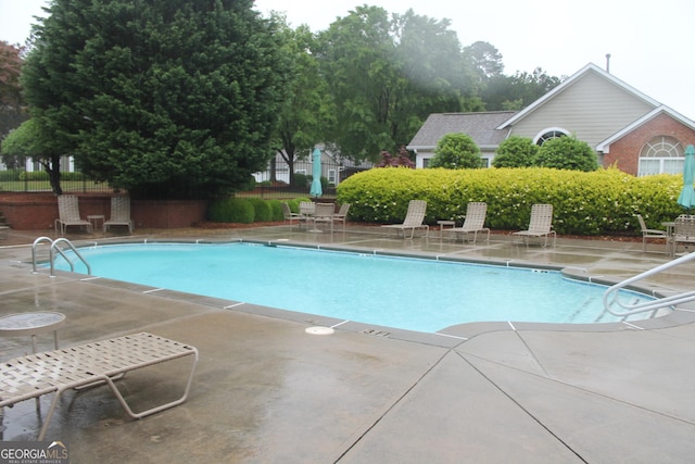 community pool featuring a patio and fence
