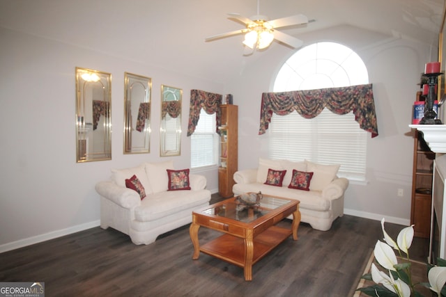 living room featuring lofted ceiling, dark wood-style flooring, a ceiling fan, and baseboards