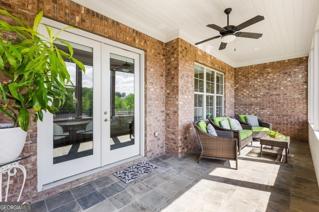 view of exterior entry with french doors, brick siding, a patio, and ceiling fan