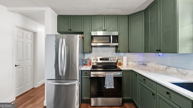 254 Merilyn Dr, Ringgold, GA 30736 - kitchen with green cabinetry, appliances with stainless steel finishes, dark wood finished floors, backsplash, and a textured ceiling