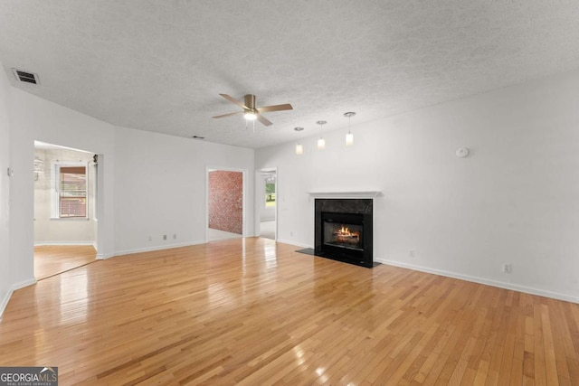 2620 Dr Bramblett Rd, Cumming, GA 30028 - unfurnished living room featuring a ceiling fan, a textured ceiling, healthy amount of natural light, and light wood-style flooring