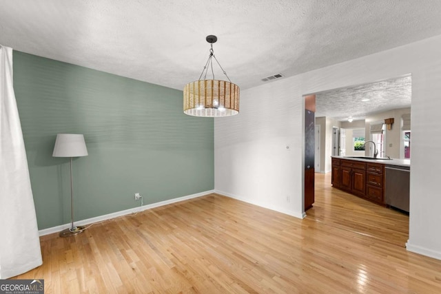 2620 Dr Bramblett Rd, Cumming, GA 30028 - unfurnished dining area with a sink, light wood-style flooring, a textured ceiling, and baseboards