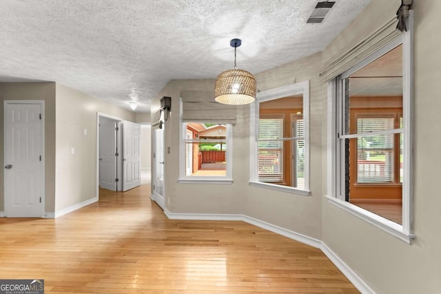 2620 Dr Bramblett Rd, Cumming, GA 30028 - unfurnished dining area featuring light wood finished floors, baseboards, and a textured ceiling