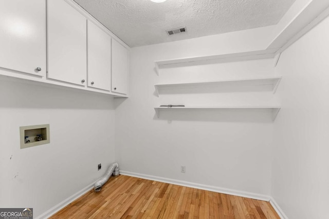 2620 Dr Bramblett Rd, Cumming, GA 30028 - laundry room featuring washer hookup, cabinet space, light wood-type flooring, baseboards, and a textured ceiling