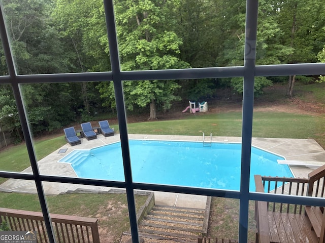 outdoor pool featuring a yard and a diving board