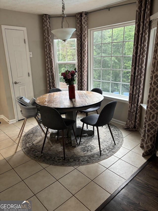 dining area featuring light tile patterned floors and baseboards