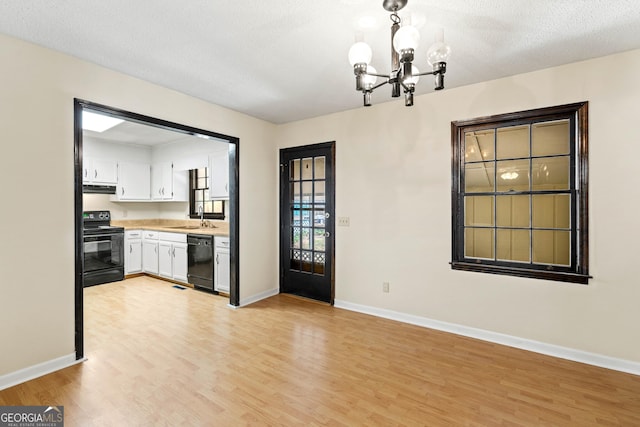 121 Stonewood Dr, Toccoa, GA 30577 - kitchen with black appliances, a sink, a chandelier, light wood-type flooring, and a textured ceiling