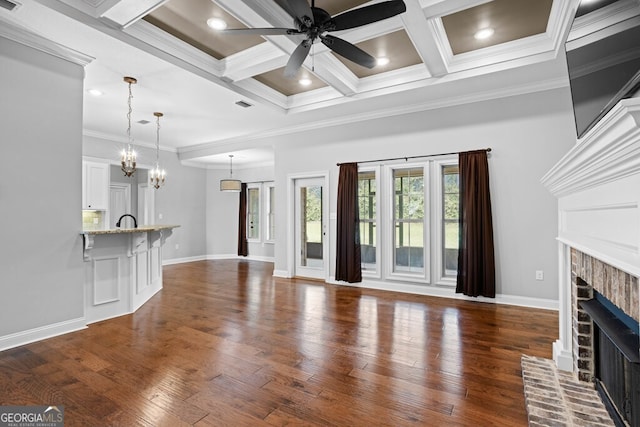 4227 Tillman Blf, Valdosta, GA 31602 - unfurnished living room with a brick fireplace, a ceiling fan, crown molding, dark wood finished floors, and beam ceiling