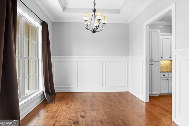 4227 Tillman Blf, Valdosta, GA 31602 - unfurnished dining area with a chandelier, wood finished floors, a decorative wall, wainscoting, and ornamental molding
