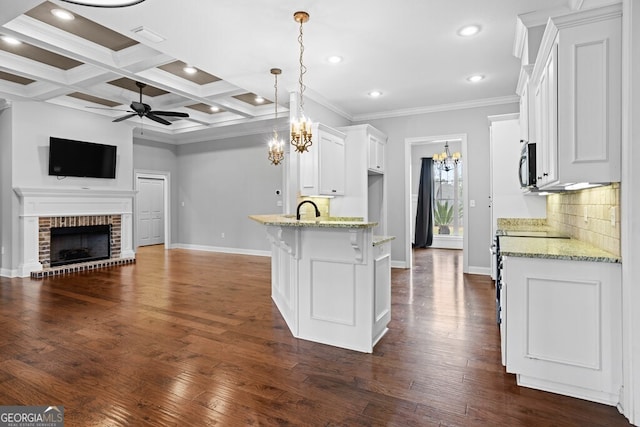 4227 Tillman Blf, Valdosta, GA 31602 - kitchen with a ceiling fan, stainless steel microwave, baseboards, white cabinets, and a peninsula