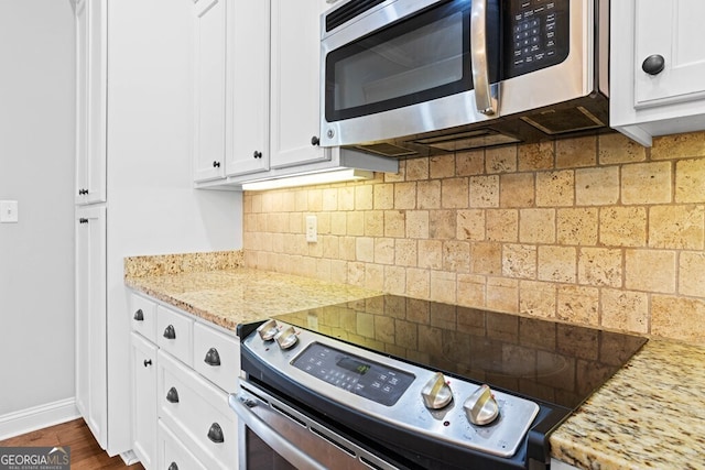 4227 Tillman Blf, Valdosta, GA 31602 - kitchen with stainless steel appliances, white cabinets, decorative backsplash, baseboards, and light stone counters