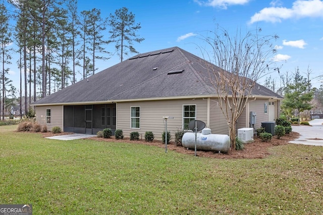 4227 Tillman Blf, Valdosta, GA 31602 - back of property with central AC unit, a sunroom, a yard, and a shingled roof