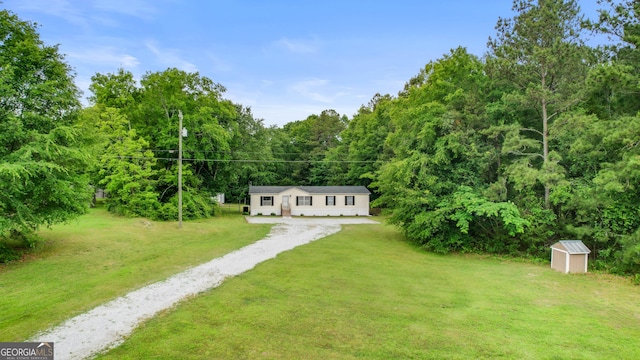 2021 Wyche Cir, Elberton, GA 30635 - view of green lawn with driveway, an outbuilding, a shed, and a view of trees