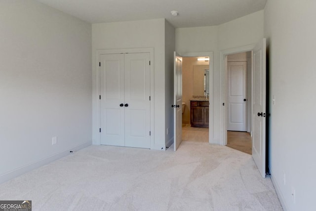 3066 Reserve Ct SW, Conyers, GA 30094 - unfurnished bedroom with light colored carpet, a closet, baseboards, and connected bathroom