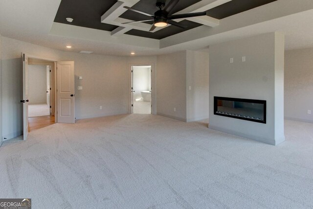 3066 Reserve Ct SW, Conyers, GA 30094 - unfurnished living room featuring carpet flooring, a ceiling fan, recessed lighting, coffered ceiling, and a glass covered fireplace