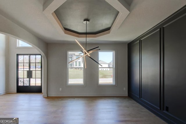 3066 Reserve Ct SW, Conyers, GA 30094 - unfurnished dining area featuring arched walkways, light wood finished floors, a raised ceiling, and baseboards