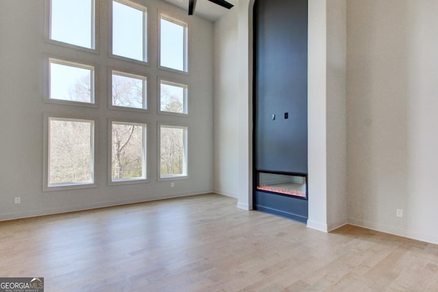 3066 Reserve Ct SW, Conyers, GA 30094 - unfurnished room with light wood-style floors, baseboards, arched walkways, and a high ceiling