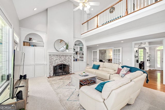 490 Water Wheel Ct, Cornelia, GA 30531 - living room with built in shelves, a ceiling fan, high vaulted ceiling, a brick fireplace, and wood finished floors