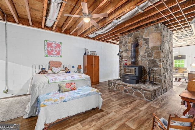 490 Water Wheel Ct, Cornelia, GA 30531 - bedroom featuring wood finished floors, a wood stove, ensuite bath, and concrete block wall