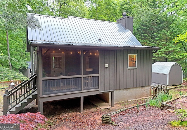 785 Bernhardt Rd, Ellijay, GA 30536 - back of property with a sunroom, a chimney, board and batten siding, metal roof, and stairway