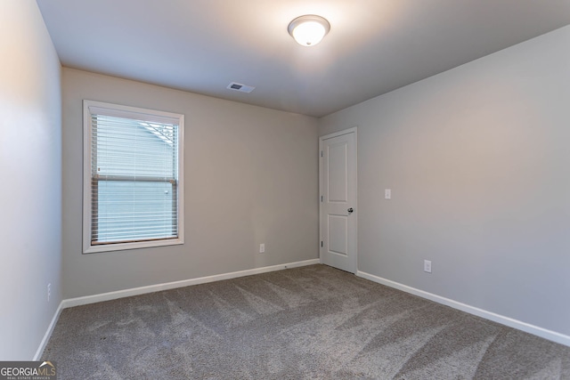 carpeted empty room featuring baseboards