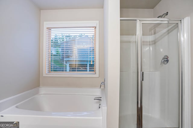 bathroom featuring a stall shower and a bath