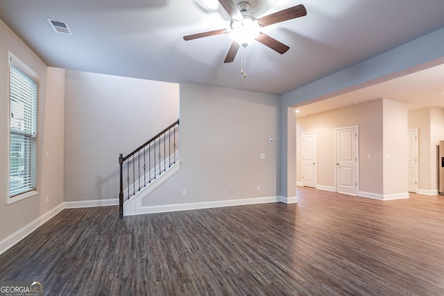 unfurnished living room featuring wood finished floors, ceiling fan, baseboards, and stairs