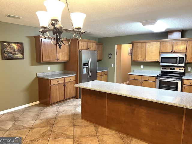 kitchen with stainless steel appliances, brown cabinets, light countertops, a chandelier, and a textured ceiling