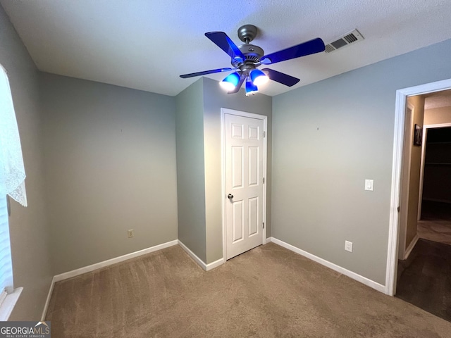 unfurnished bedroom featuring carpet floors, baseboards, and a ceiling fan