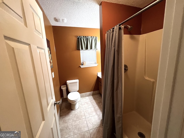 full bath featuring a stall shower, toilet, tile patterned floors, a textured ceiling, and vanity