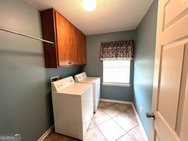 laundry area with washer and dryer, cabinet space, a textured ceiling, baseboards, and light tile patterned floors