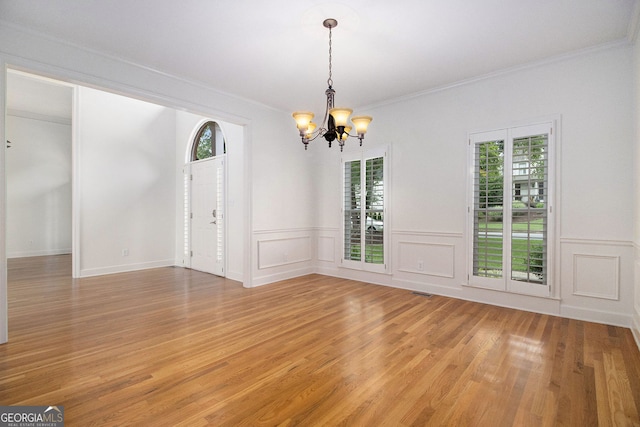 315 Hembree Grove Trce, Roswell, GA 30076 - empty room featuring plenty of natural light, a chandelier, light wood-style flooring, crown molding, and a wainscoted wall