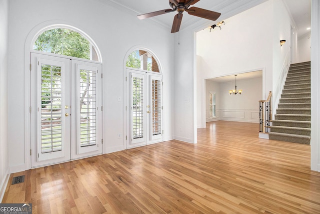 315 Hembree Grove Trce, Roswell, GA 30076 - unfurnished living room featuring french doors, stairs, light wood-style floors, ornamental molding, and a chandelier