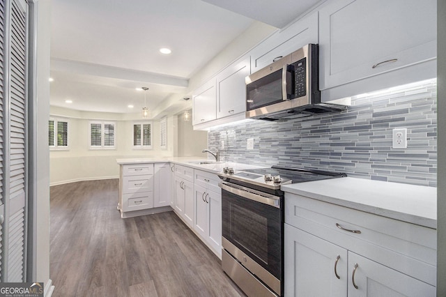 315 Hembree Grove Trce, Roswell, GA 30076 - kitchen with stainless steel appliances, a peninsula, tasteful backsplash, white cabinetry, and dark wood finished floors