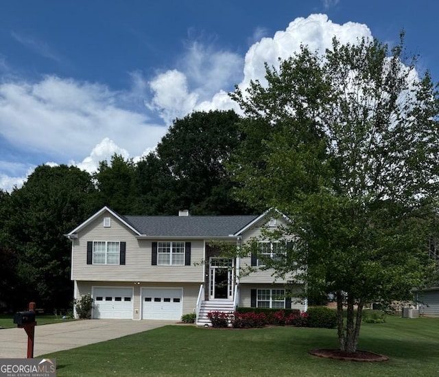 343 Ashton Way, Winder, GA 30680 - raised ranch featuring a garage, a front yard, concrete driveway, and a chimney