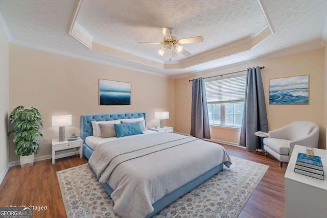 343 Ashton Way, Winder, GA 30680 - bedroom with ornamental molding, a tray ceiling, wood finished floors, a textured ceiling, and baseboards