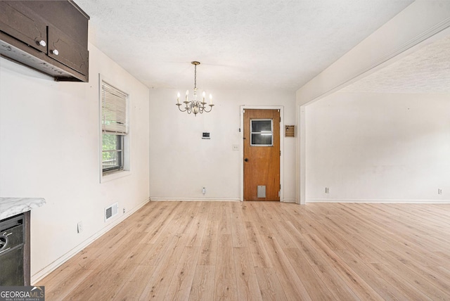 2954 Ann Marie Ln, Rex, GA 30273 - unfurnished dining area with light wood-style floors, a chandelier, and a textured ceiling