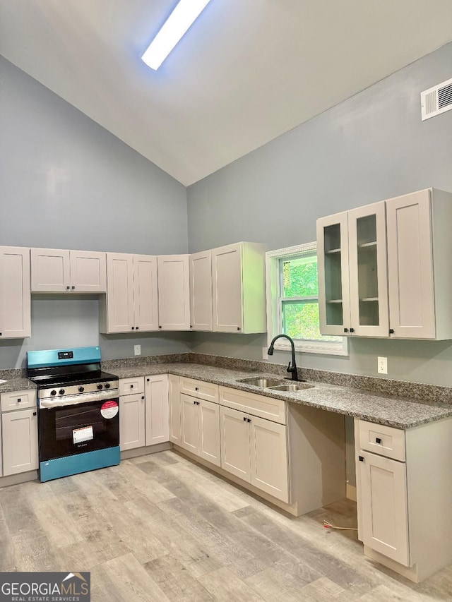 201 Deerfield Ln, Carrollton, GA 30116 - kitchen featuring a sink, stainless steel range with electric stovetop, high vaulted ceiling, light wood-style floors, and glass insert cabinets