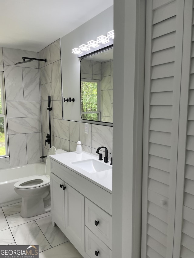 bathroom with marble finish flooring, tile walls, toilet, vanity, and shower / bath combination