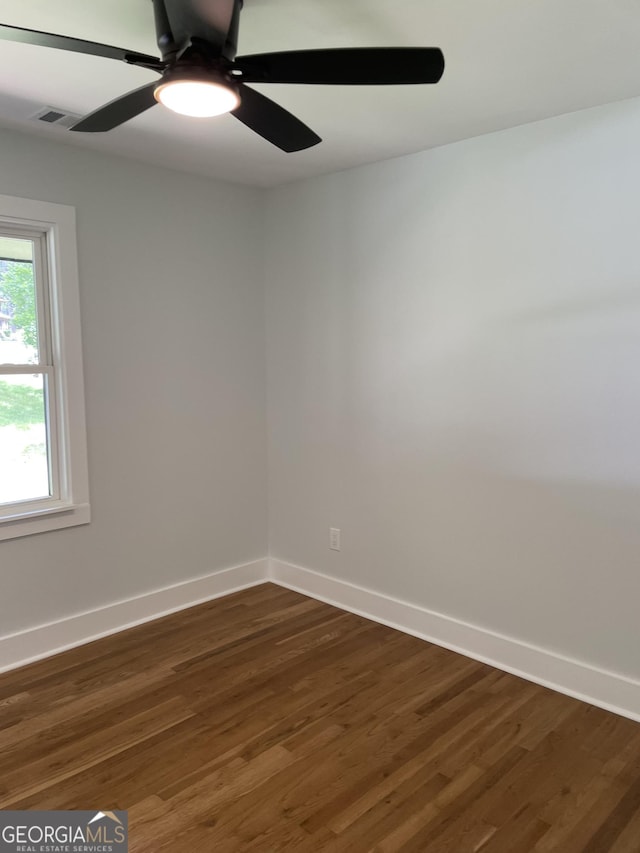 unfurnished room featuring wood finished floors, a ceiling fan, and baseboards