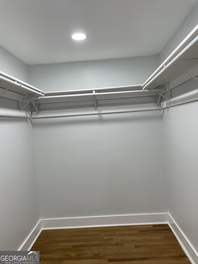 walk in closet with dark wood-type flooring