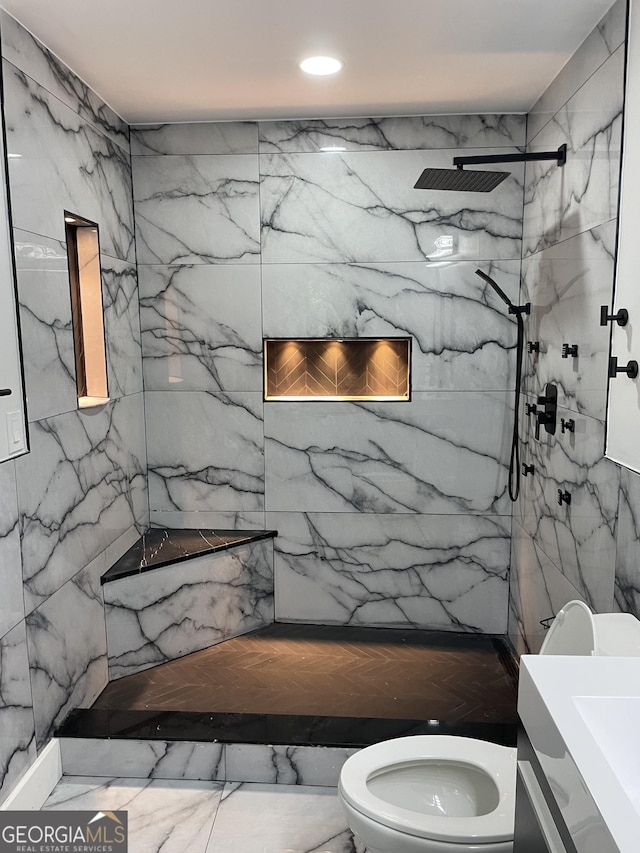 bathroom with toilet, a marble finish shower, marble finish floors, and vanity