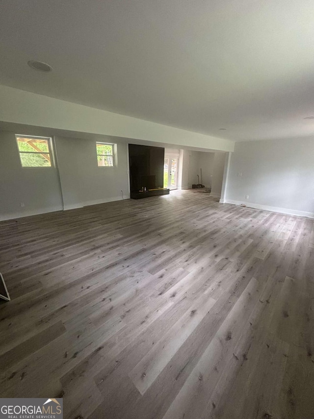 unfurnished living room with wood finished floors and baseboards