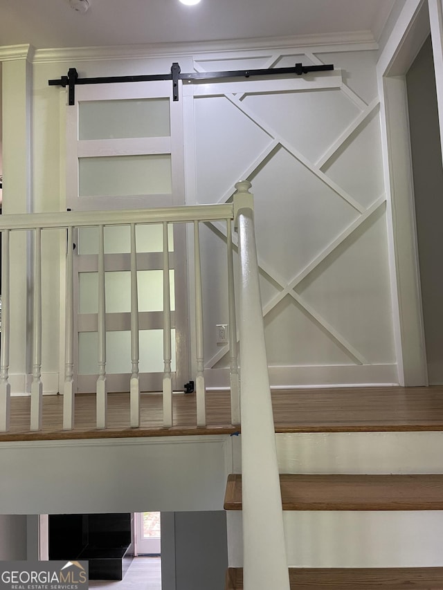 stairs featuring a barn door and ornamental molding