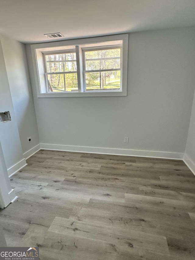 unfurnished room with baseboards and wood finished floors