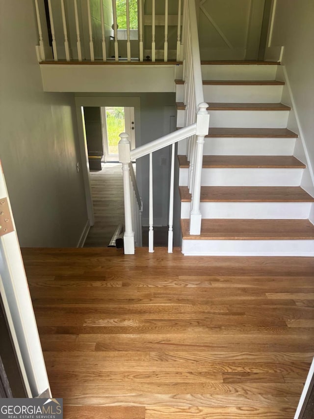 stairway featuring wood finished floors and baseboards