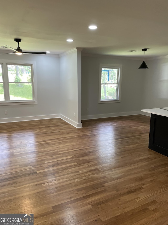 unfurnished living room featuring ornamental molding, ceiling fan, baseboards, recessed lighting, and dark wood finished floors