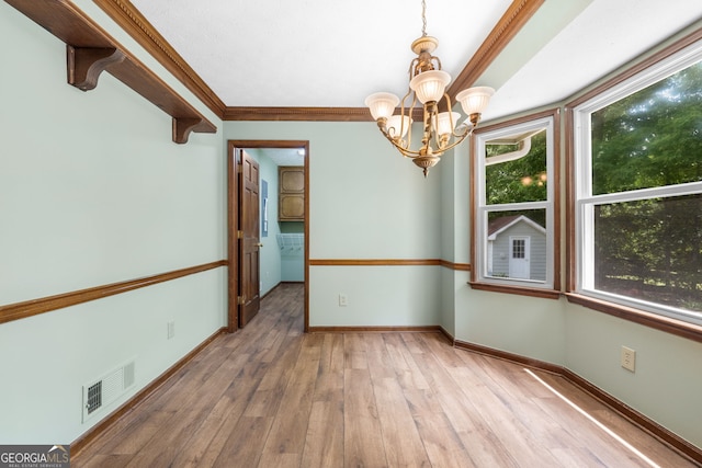unfurnished dining area with a chandelier, light wood-type flooring, baseboards, and ornamental molding