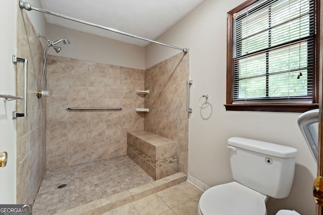 full bath with toilet, tiled shower, tile patterned floors, and baseboards