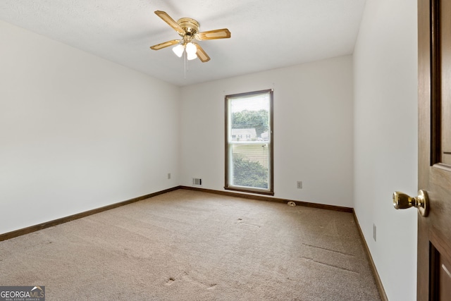 empty room with carpet floors, ceiling fan, and baseboards